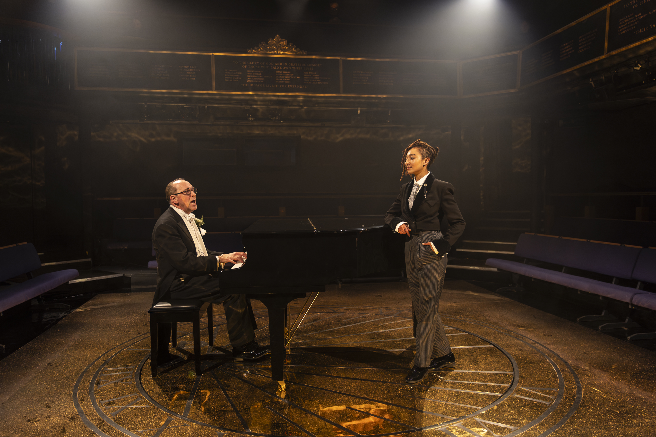 Stefan Bednarczyk sits at the piano and sings to Patricia Allison